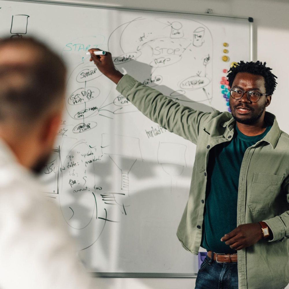 African American Man at Whiteboard describing Concept