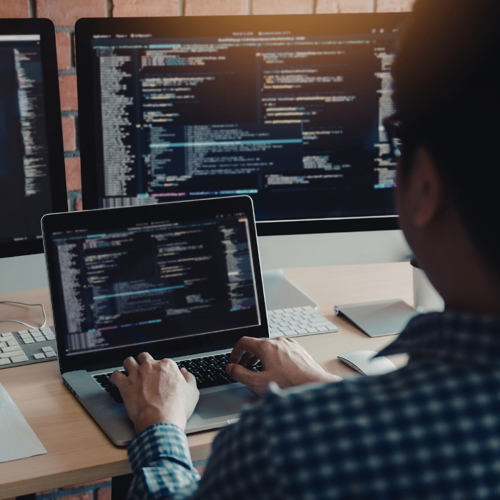 Male Sitting In Front of Computers Building Code