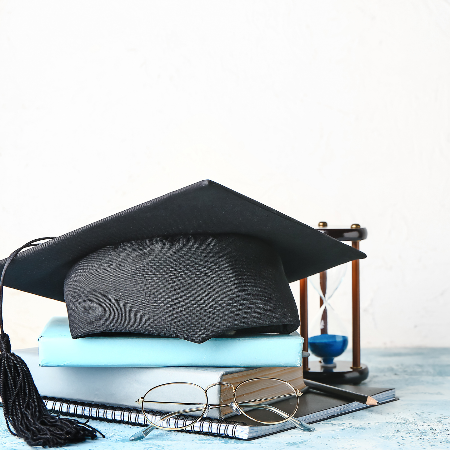 Black Graduation Cap On Top of Books