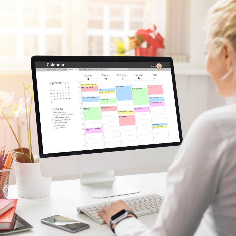 Female Sitting In Front of A Computer With A Calendar On The Monitor Screen